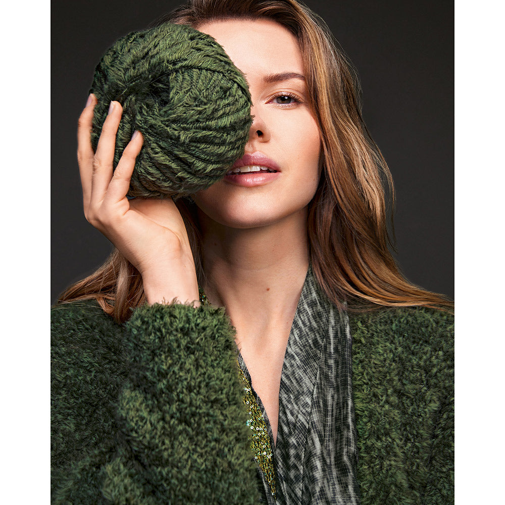 Inspiratiefoto bij Lana Grossa Pelliccia 016 Bordeaux: vrouw houdt een donkergroene garenbol bij haar gezicht - Lana Grossa Pelliccia 001 Crème