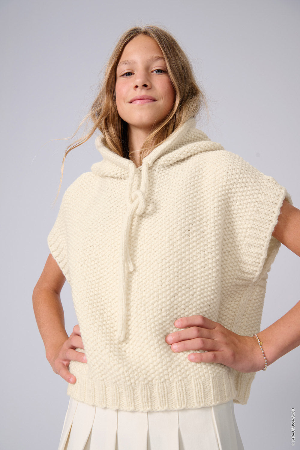 vrouw in een crèmekleurige trui met lange franjes als inspiratie voor Lana Grossa Cool Merino Big 231 Roze - Lana Grossa Cool Merino Big 201 Ruw Wit