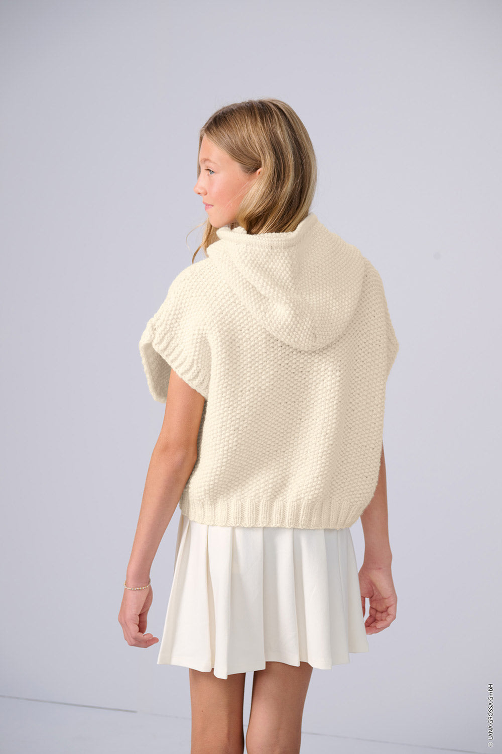 vrouw in een beige trui met lange franjes als inspiratie voor Lana Grossa Cool Merino Big 231 Roze - Lana Grossa Cool Merino Big 201 Ruw Wit