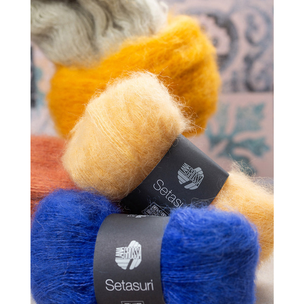Lana Grossa Setasuri 062 Umbra - sfeerfoto met gestapelde bollen Lana Grossa Setasuri in oranje, geel en blauw - sfeerfoto 32 - Lana Grossa Setasuri 068 Framboos